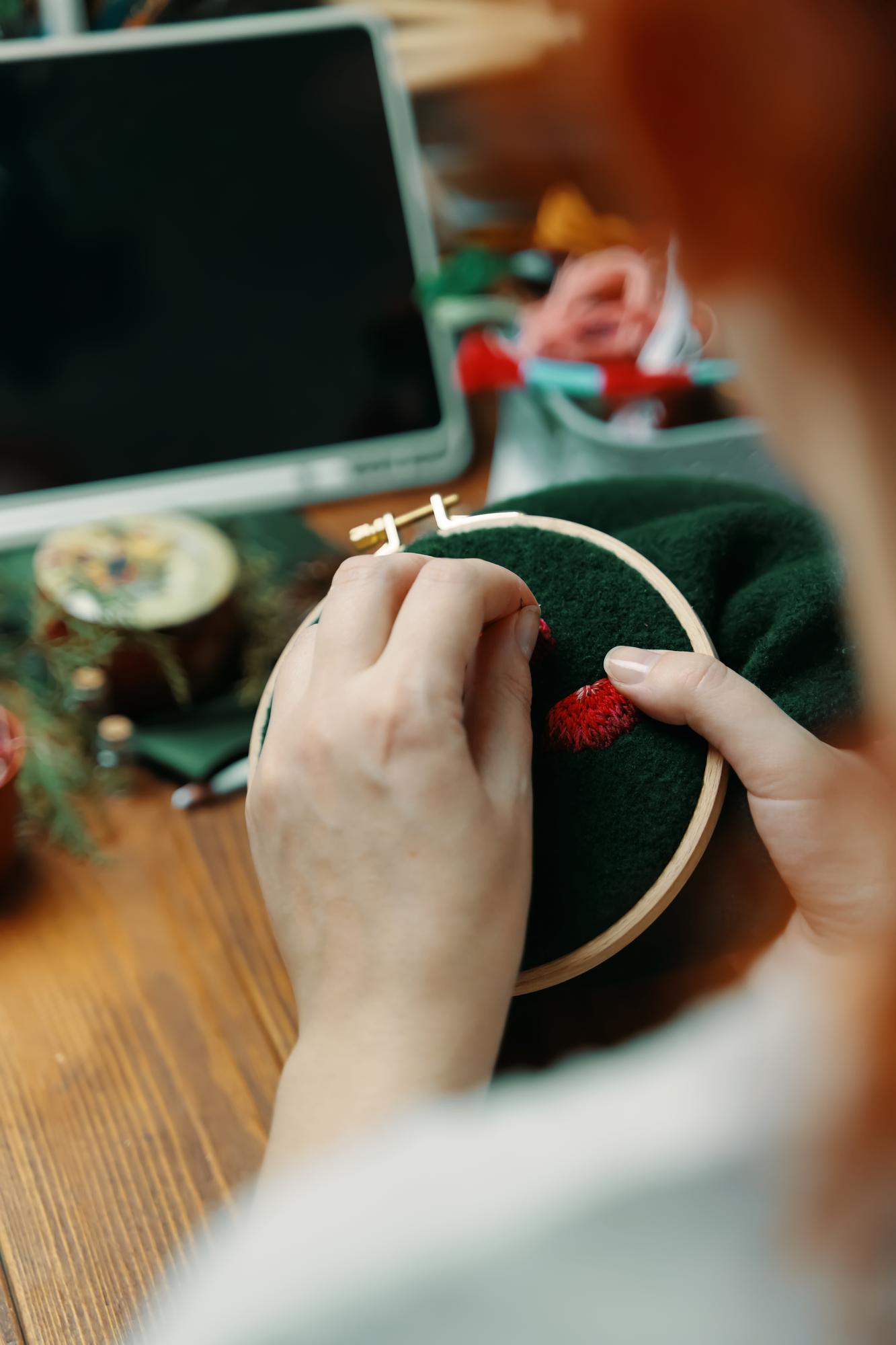 Mentorė demonstruoja siuvinėjimo techniką